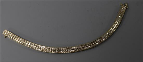 A modern 14ct gold and twin row diamond set line bracelet, with a total carat weight of 5.05cts, 18.3cm.